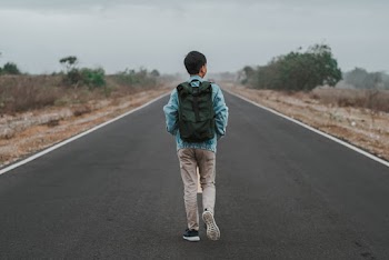Photo of Man Walking on Road
