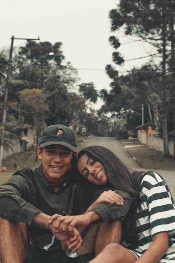 Photo of Man Wearing Cap Sitting Beside Woman
