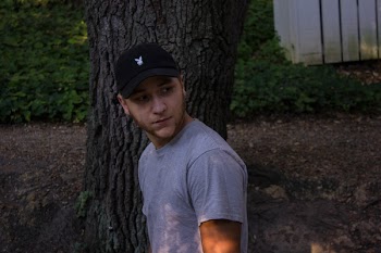 Photo of Man Wearing Gray Shirt Standing Near Tree