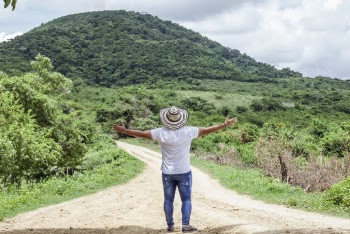 Photo of Man Wearing Hat While Standing on Dirt Road