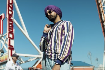Photo of Man Wearing Striped Long Sleeved Shirt and Purple Turban