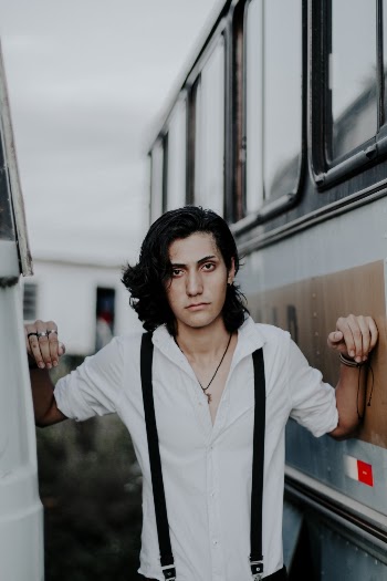 Photo of Man Wearing White Dress Shirt Posing in Between Two  Buses