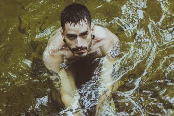 Photo of Man With Tattoos on Body of Water