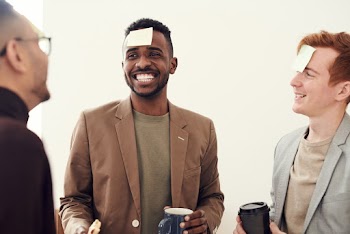 Photo of Men Smiling While Holding a Cup