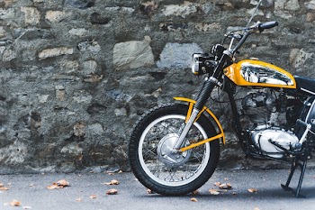 Photo of Motorcycle Parked Beside a Concrete Wall