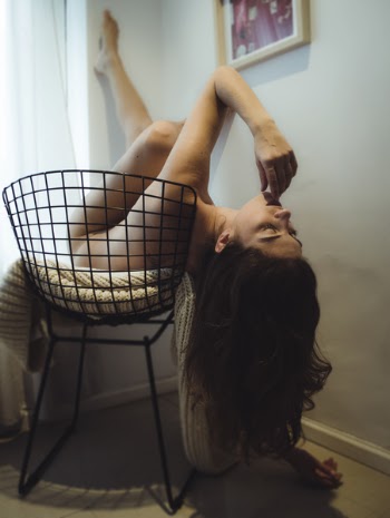 Photo of Naked Woman Lying on Black Metal Chair