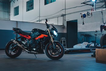 Photo of Orange and Black Motorcycle Parked in Warehouse