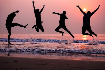 Photo of People Doing Jump Shot on Beach