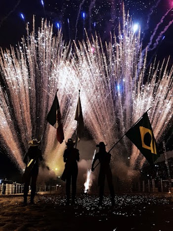 Photo Of People Holding Flags Near Fireworks