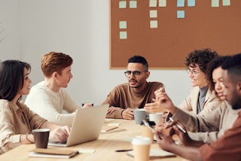 Photo Of People Near Cork Board