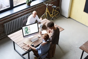 Photo Of People Near Wooden Table