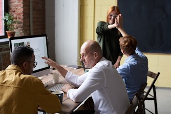 Photo Of People Near Wooden Table