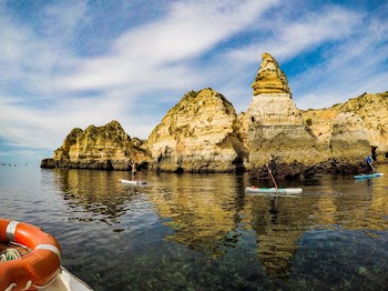 Photo of People on Canoe Near Rock Formations