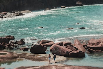 Photo of People On Rocky Shore