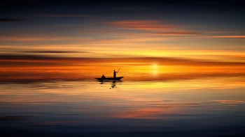 Photo of People on Rowboat During Sunset