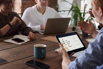 Photo Of People Sitting Near Wooden Table