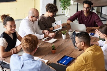 Photo Of People Sitting Near Wooden table
