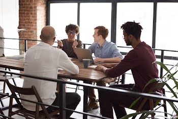 Photo Of People Sitting Near Wooden Table