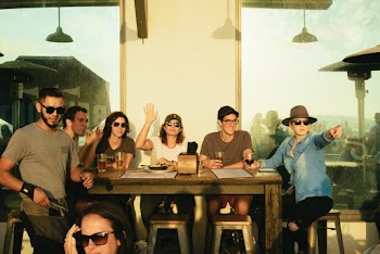 Photo of People Sitting on Chairs Near Wooden Table