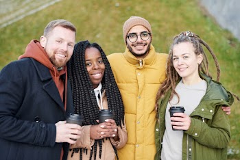 Photo of People Smiling While Holding Disposable Cups