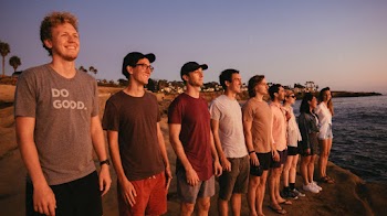 Photo Of People Standing Beside Sea
