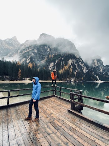Photo of People Standing on a Lake Boardwalk