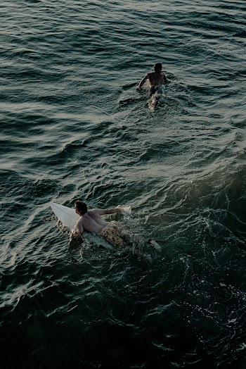 Photo Of People Surfing In The Ocean