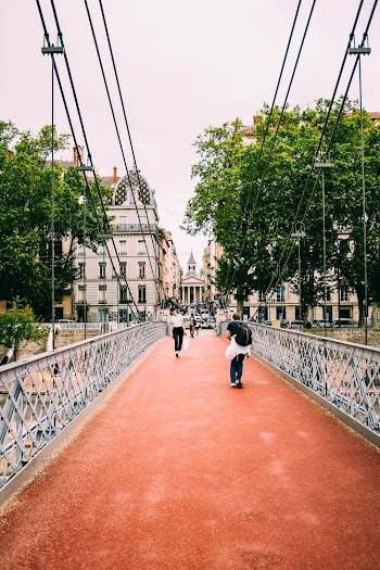 Photo of People Walking Along Footbridge