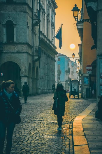 Photo of People Walking on Cobblestone Street