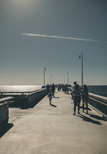 Photo Of People Walking On Concrete Bridge