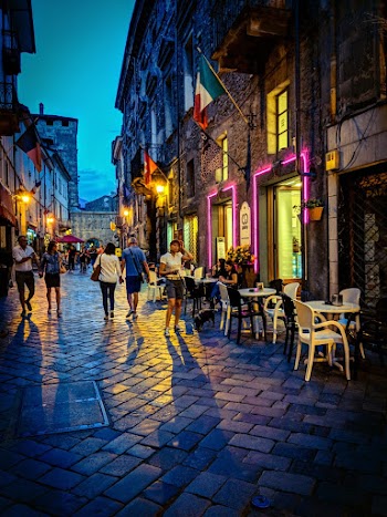 Photo of People Walking on Interlocking Concrete Street Next to Restaurant during Nighttime