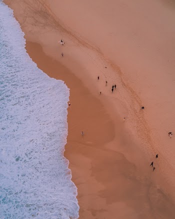 Photo of People Walking on Seashore
