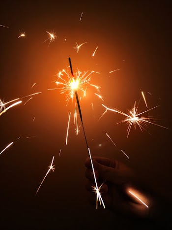Photo of Person's Hand Holding a Sparkler
