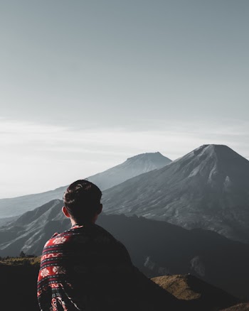 Photo of Person Atop Mountains