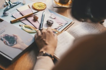Photo Of Person Holding Notebook Near Pen 