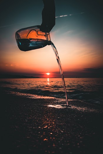 Photo of Person Pouring Water on Sand