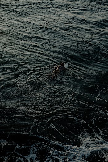 Photo Of Person Riding On Surfboard