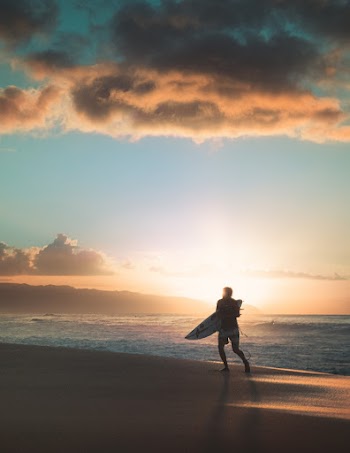 Photo of Person Running on Beach During Golden Hour