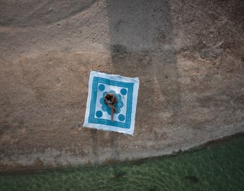 Photo of Person Sitting Near Body of Water