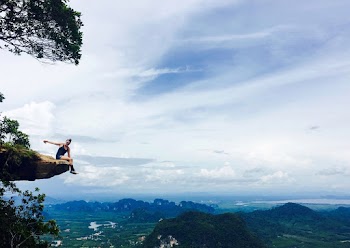 Photo of Person Sitting on Cliff