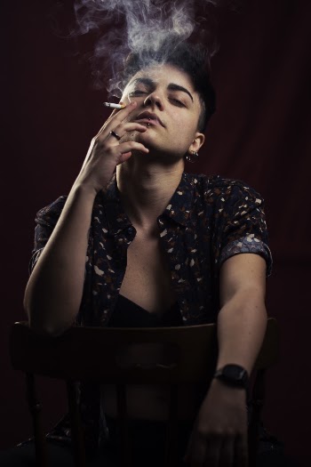 Photo of Person Smoking While Sitting on Chair