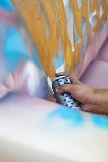 Photo of Person Spraying Paint on Wall