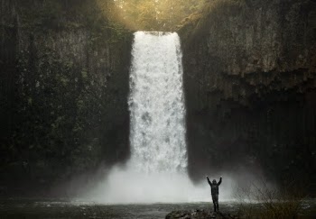 Photo of Person Standing Near Waterfalls
