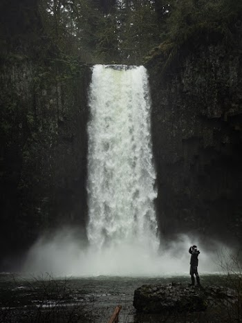 Photo of Person Standing Near Waterfalls