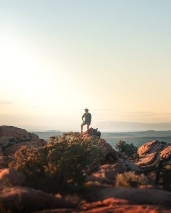 Photo of Person Standing on Cliff