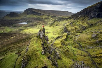 Photo of Person Standing on Rock Formation