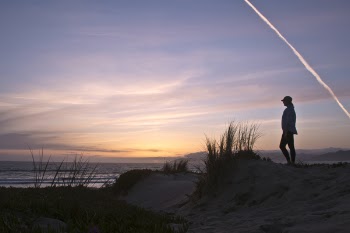 Photo of Person Standing On Sand During Dawn