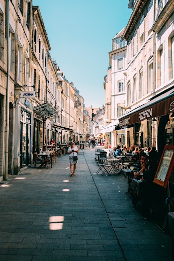 Photo of Person Walking Between Buildings