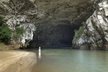 Photo of Person Walking Near Cave