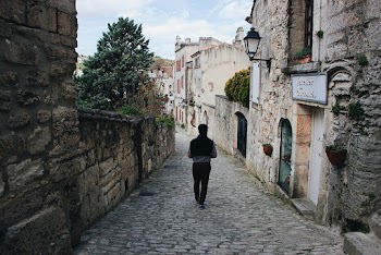 Photo of Person Walking on Cobblestreet